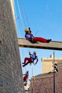 photo de cordistes suspendu à une corde contre un mur